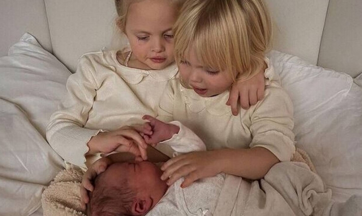 Παιδιά ποζάρουν στον φωτογραφικό φακό με το νεογέννητο αδερφάκι τους